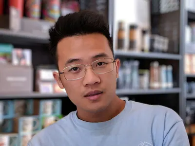 man wearing eyeglasses and blue shirt inside coffee shop